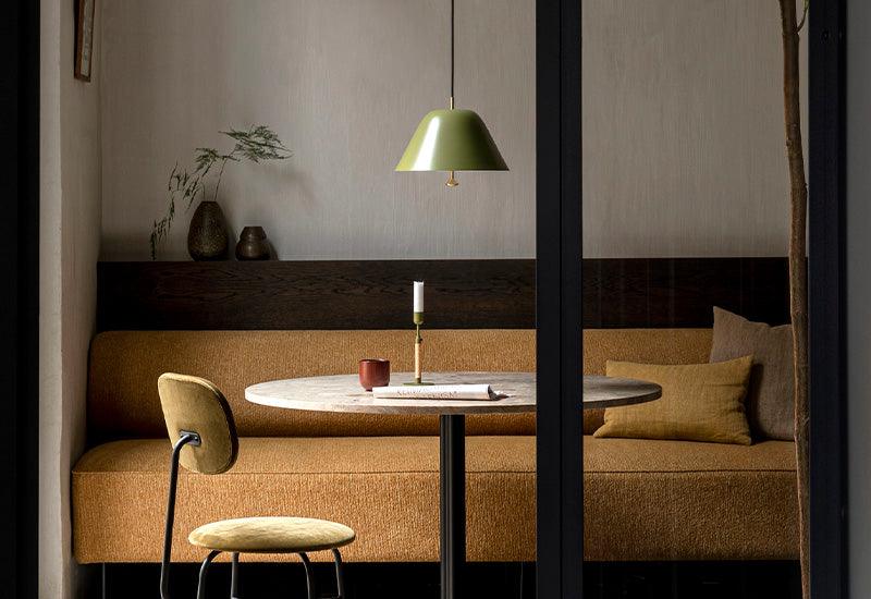 The Levitate Pendant in sage green displayed over a table.