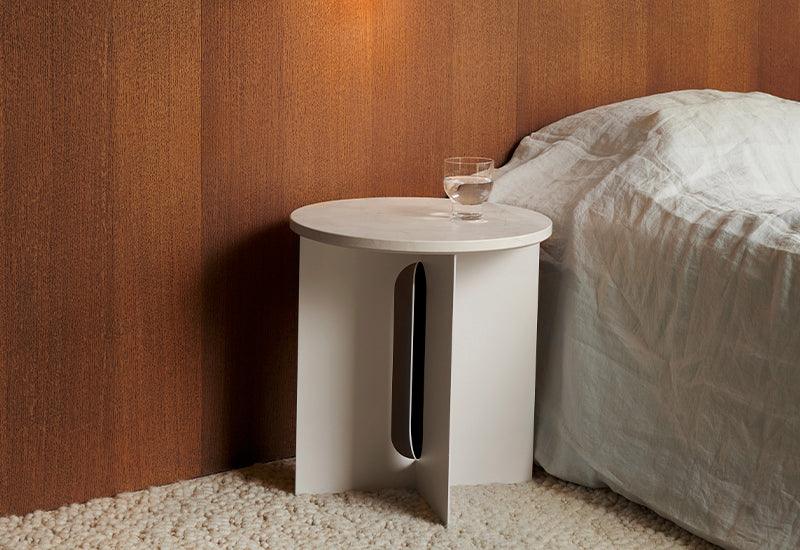 The Androgyne Side Table by Danielle Siggerud for Audo Copenhagen in ivory with crystal rose table top used as a bedroom side table.