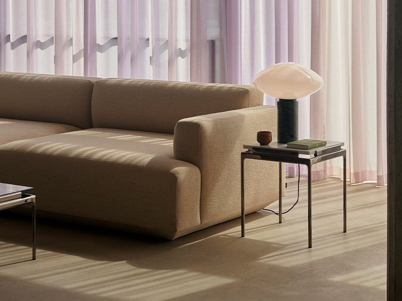 A Sett Side Table next to a beige sofa. Designed by Luca Nichetto for &Tradition.