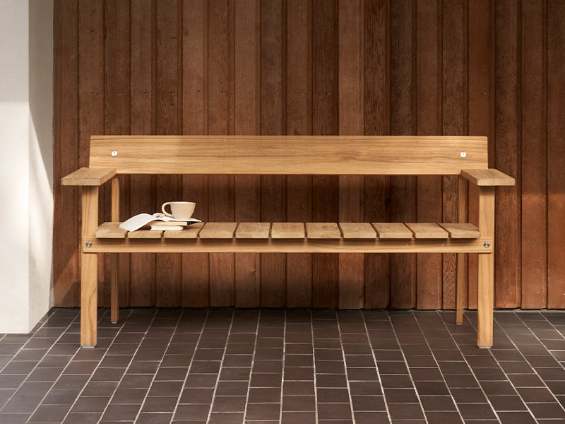 A GL101 Timbur Outdoor Bench with a cup of tea andbook rested on the seat.