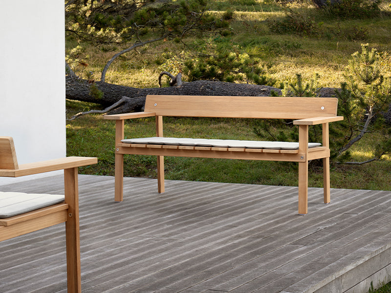  A cushioned GL101 Timbur Outdoor Bench, outside.