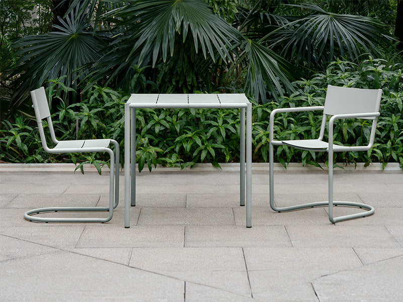 The Sine dining armchair, chair and small table in grey.