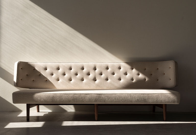 The Radiohus Sofa P3 by Vilhem Lauritzen for Audo Copenhagen with strong shadows cast around it.