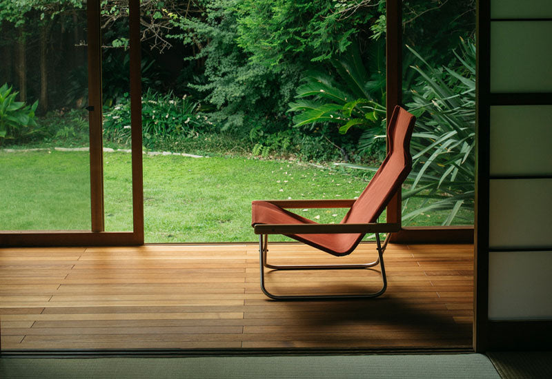 The Nychair X chair in terracotta in front of a window.