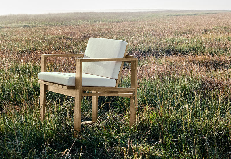 The BK10 dining chair by Bodil Kjaer for Carl Hansen & Son in a field.