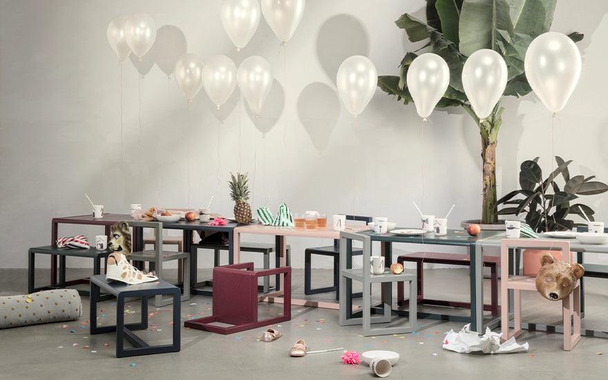 A row of Ferm Living Architect Tables in various colours featured in an empty party scene.