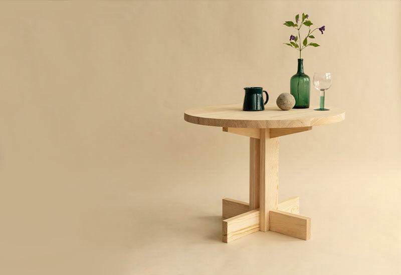 The 001 Dining Table with various products displayed on top. Designed by Fredrik Paulsen for Vaarnii.