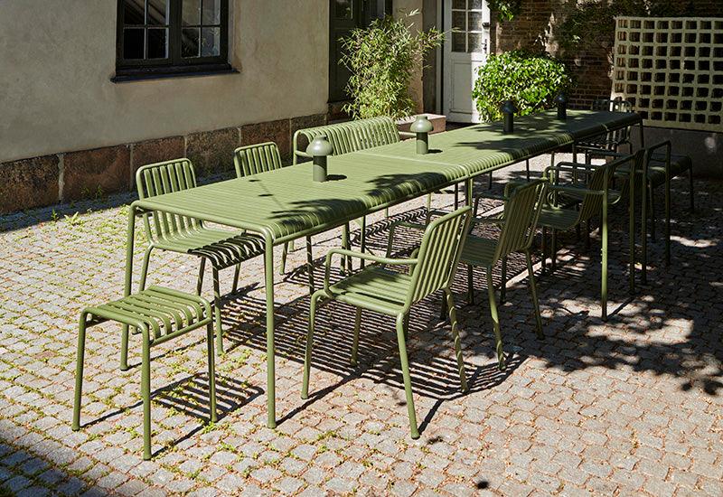 The HAY Palissade large rectangular table in Olive, in an outdoor dining setting.