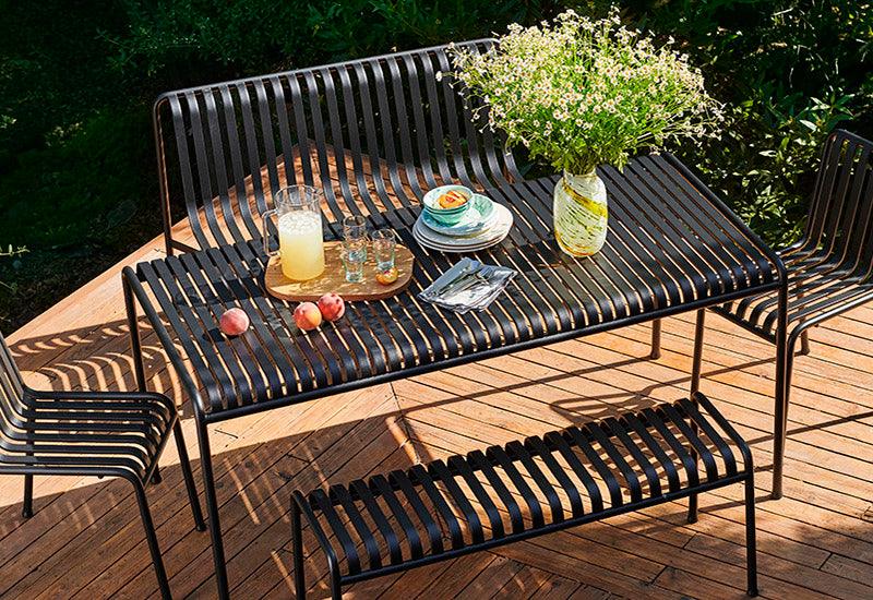 The HAY Palissade large rectangular table in Anthracite, in an outdoor dining setting.