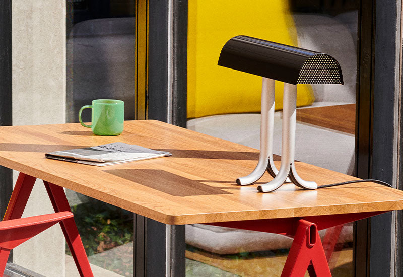 The Anagram Table Lamp by Sam Weller for HAY in iron black on a desk.