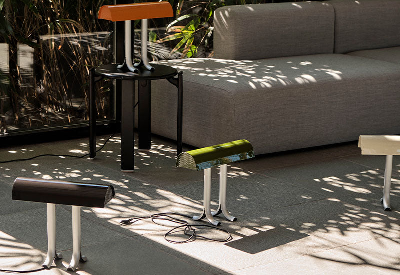 The Anagram Table Lamp by Sam Weller for HAY in all four colours in a room with large windows.