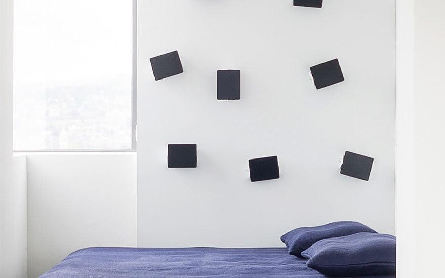  Numerous Applique à Volet Pivotant wall lights by Charlotte Perriand for Nemo Lighting cover a bedroom wall.
