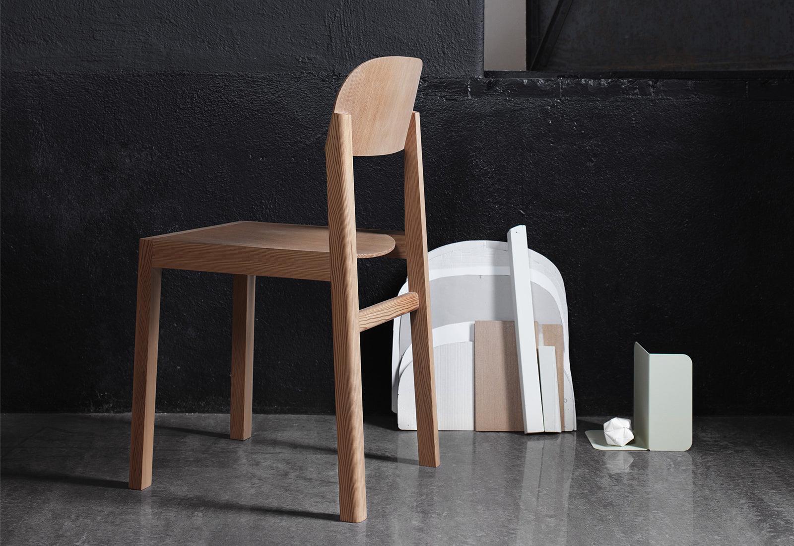 Workshop chair by Cecilie Manz for Muuto in front of a black wall.