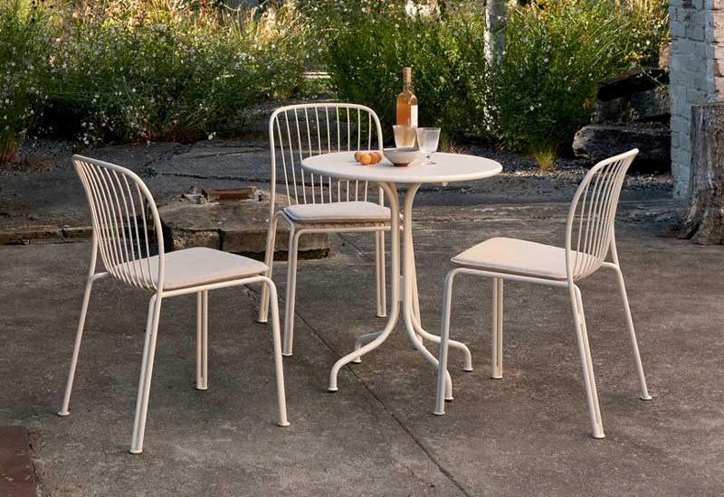  A trio of ivory Thorvald Side Chairs by Space Copenhagen for &tradition with the cafe table of the same range.