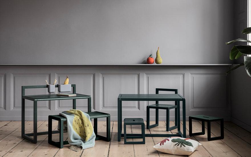  The Little Architect Bench by Ferm Living in dark green. The bench is displayed amongst other items from the Little Architect Collection.