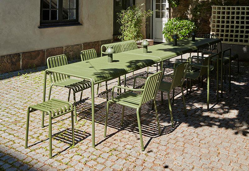  The HAY Palissade large rectangular table in Olive, in an outdoor dining setting.