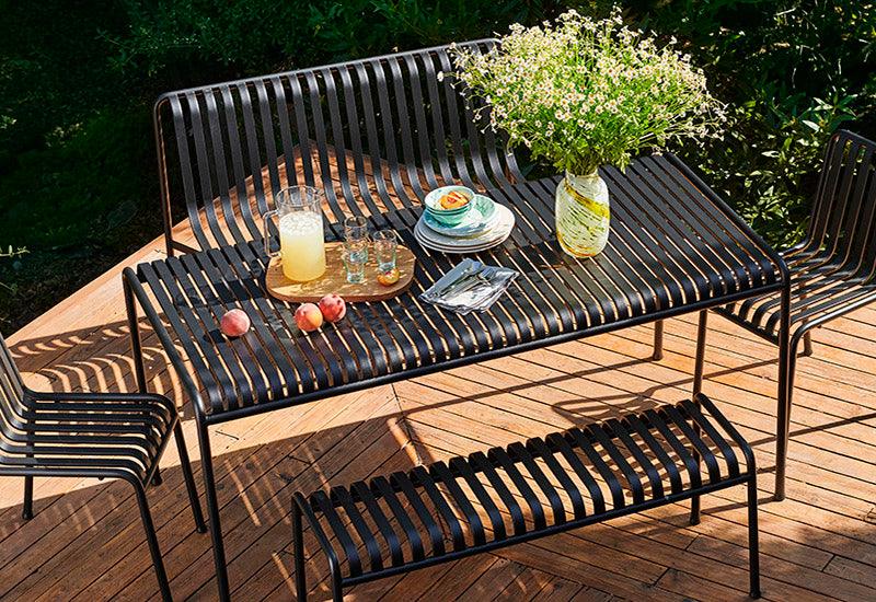  The HAY Palissade large rectangular table in Anthracite, in an outdoor dining setting.